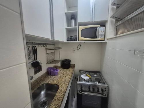 een kleine keuken met een spoelbak en een magnetron bij SUH Copacabana 143 in Rio de Janeiro