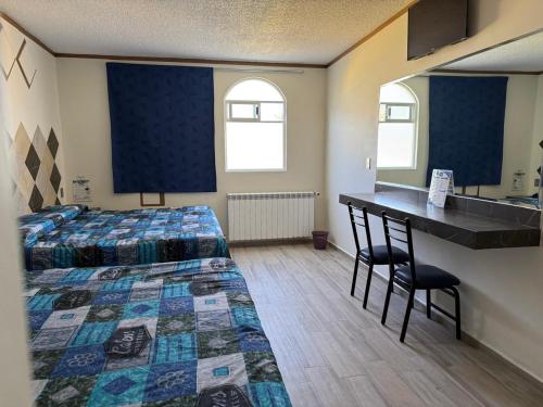 a hotel room with two beds and a desk and a desk at Hotel-Motel Calens in Velasco