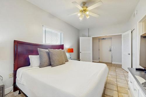 ein Schlafzimmer mit einem weißen Bett mit Deckenventilator in der Unterkunft Waters Edge 501 in Fort Walton Beach