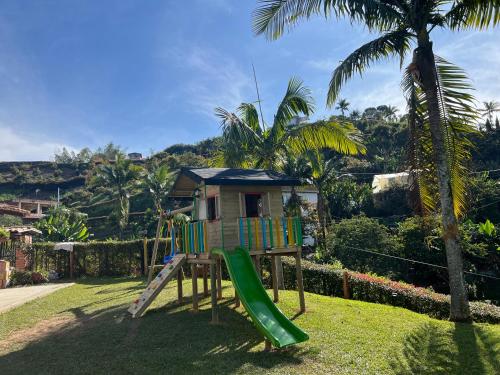 a playground with a slide in front of a house at Villa El Colibri in El Peñol