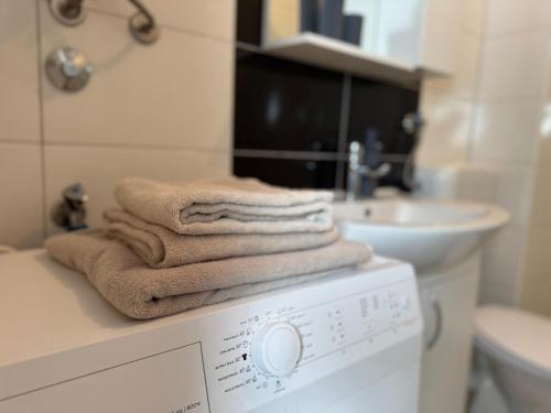 een stapel handdoeken bovenop een wasmachine bij Odmori se, Centar apartman in Donje Mladice