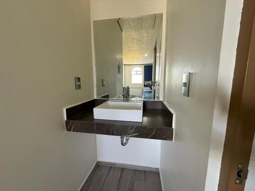 a bathroom with a sink and a mirror at Hotel-Motel Calens in Velasco