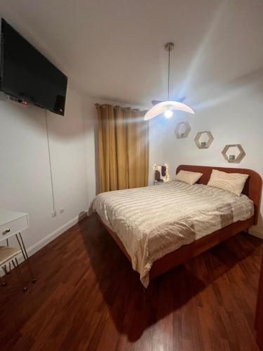 ein Schlafzimmer mit Bett und Flachbildfernseher in der Unterkunft Arena Royal Suite in Bacău