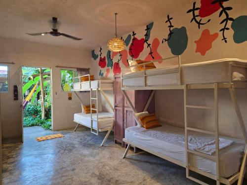 巴利亚多利德VALLADOLID 48 Hotel & Hostal的房间里有四张双层床，墙上装饰着鲜花。