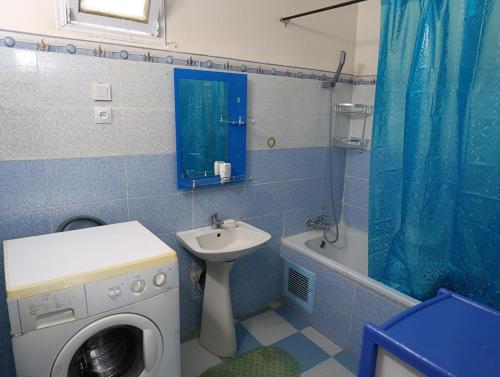 baño azul con lavadora y lavamanos en Beautiful cozy house in Constantine with amazing views, en Constantina