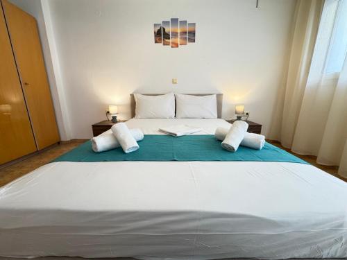a large white bed in a room with two lamps at Dimado Family in Kavála