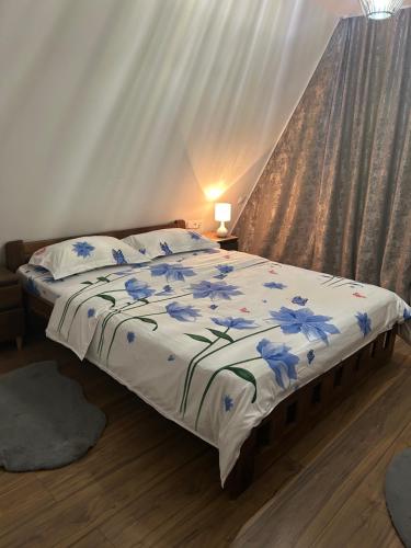 una camera da letto con un letto con fiori blu sopra di Cabana Icas a Dej