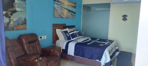 a bedroom with a bed and a chair at Beachfront Harbor 171 Condo Ocean View Pool, Gym WiFi in Puerto Vallarta