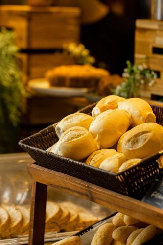 a bunch of bread in a basket on a table at Nobile Inn London Anápolis in Anápolis