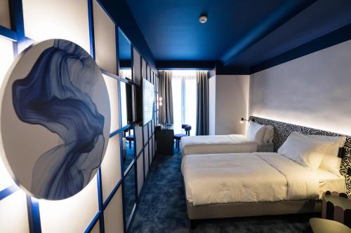 une chambre avec deux lits et un canapé dans l'établissement Mercure Bucharest Cantemir, à Bucarest