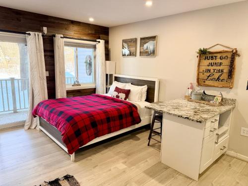 a bedroom with a bed with a plaid blanket at A113 Loon Mountain Studio Apartment with Pool and Hot Tub in Lincoln
