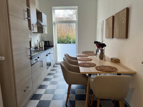 a kitchen with a table and chairs in a kitchen at MS-Apartments I Quartier 4 in Leer