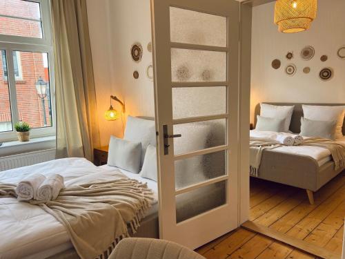 two beds in a room with a window at MS-Apartments I Quartier 4 in Leer