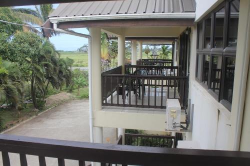 a balcony of a house with a table and chairs at Shalini Garden Hotel & Apartments in Singatoka