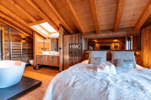een slaapkamer met een groot bed en een badkamer bij Chalet « Le 1712 » direct pistes in Les Angles