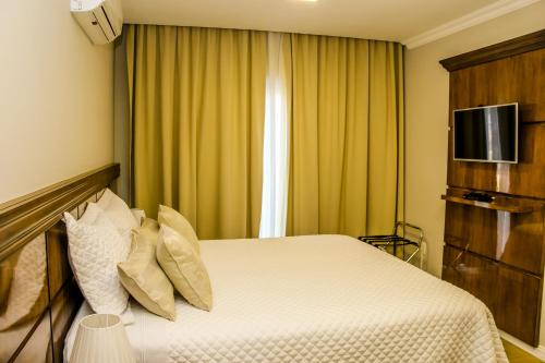 a hotel room with a bed and a television at Hotel Gramado Interlaken in Gramado