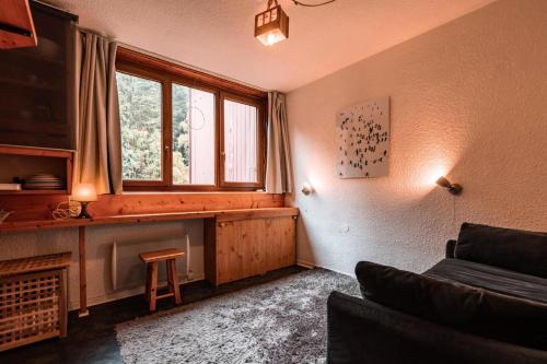 un salon avec un canapé et une fenêtre dans l'établissement Résidence Nova - Studio 2 personnes, proche des pistes et des commerces, au cœur de la station d’Arc 1800 dans le village des Villards MAE-2572, à Arc 1800