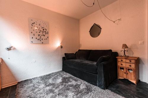 un salon avec un canapé noir et une table dans l'établissement Résidence Nova - Studio 2 personnes, proche des pistes et des commerces, au cœur de la station d’Arc 1800 dans le village des Villards MAE-2572, à Arc 1800