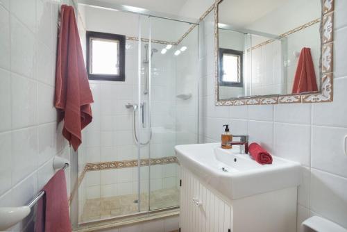 a white bathroom with a sink and a shower at Villa Punta Magdalena in El Port