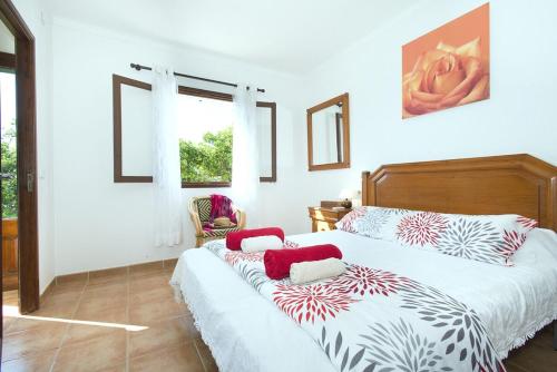 a bedroom with two beds with red and white pillows at Villa Punta Magdalena in El Port