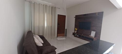 un soggiorno con divano e TV a schermo piatto di Casa Buritis a Primavera do Leste