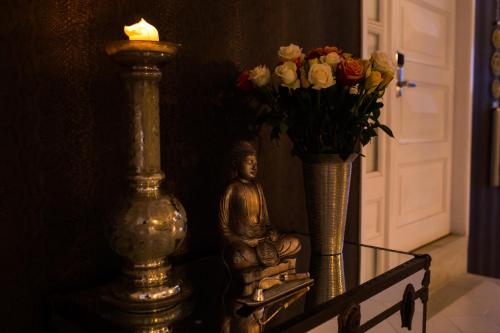 a statue and a vase with flowers on a table at Hotel Boutique El Triángulo in Armenia