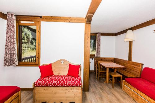 a room with a red chair and a table at CHALET DE MONTCHAVIN - Studio pour 4 Personnes MAE-9193 in Montchavin
