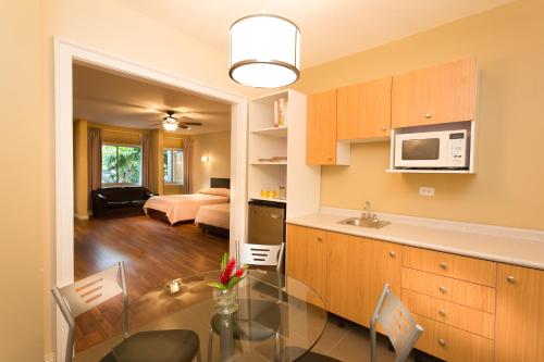 a kitchen and living room with a glass table in a room at Airport Costa Rica B&B in Alajuela