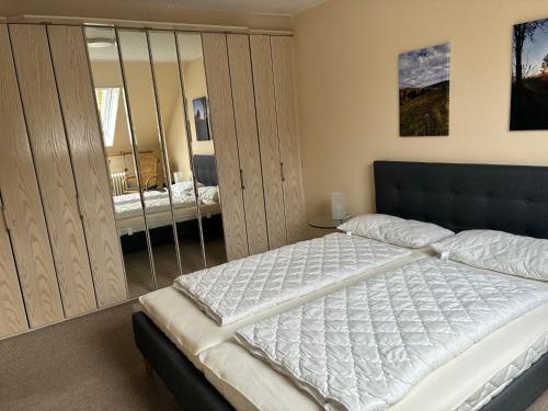 ein Schlafzimmer mit einem großen weißen Bett in einem Zimmer in der Unterkunft Harz-Urlaub-Altenau - Hunde willkommen in Altenau