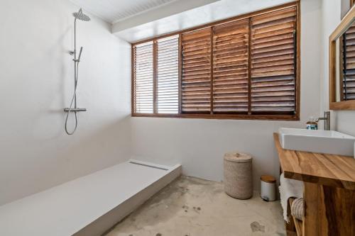 a bathroom with a tub and a sink and a window at Casa Blanca in La Trinité