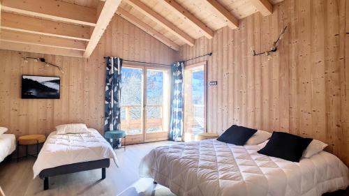 een slaapkamer met twee bedden en een groot raam bij Chalets à Saint Jean d'Aulps - BAS THEX MAE-3891 in Seytroux