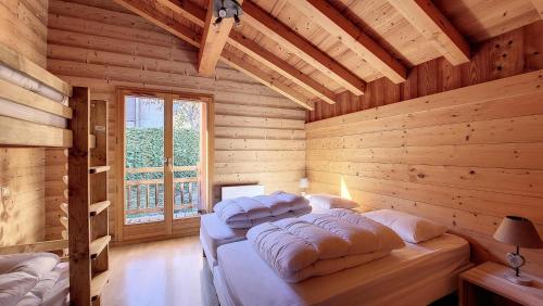 een slaapkamer met 2 bedden in een houten hut bij Chalets à Saint Jean d'Aulps - Chalet MB MAE-4101 in Saint-Jean-dʼAulps