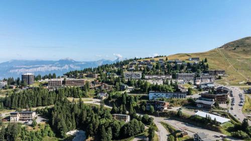 eine Luftansicht auf eine Stadt mit Bäumen und Gebäuden in der Unterkunft Chalets à Chamrousse - Chalet des lupins - Chalet 1P2 MAE-3173 in Chamrousse