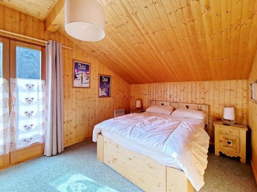 een slaapkamer met een bed in een houten hut bij Chalets à Châtel - Chalet Ecureuil ECR CHARMING & NATURE 5 Pers. MAE-3403 in Châtel