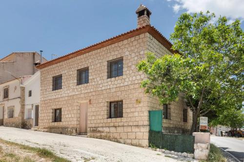 an old brick building with a tree in front of it at El Calar - Casas Rurales Luis in Moratalla