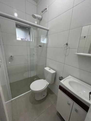 a bathroom with a toilet and a shower and a sink at HOTEL e POUSADA KF in Irapuá