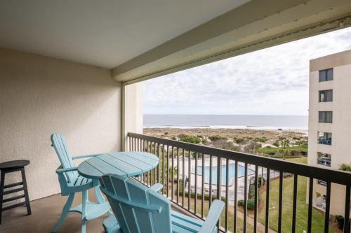 een balkon met een tafel en stoelen en uitzicht op het strand bij Surf & Racquet Club B160 -Pool in Amelia Island