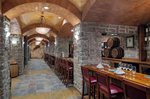 a bar in a restaurant with stone walls and chairs at Masquerade Tower at Rio Hotel & Casino by Suiteness in Las Vegas