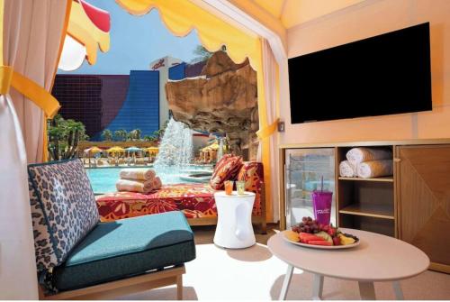 a living room with a water park in the background at Masquerade Tower at Rio Hotel & Casino by Suiteness in Las Vegas