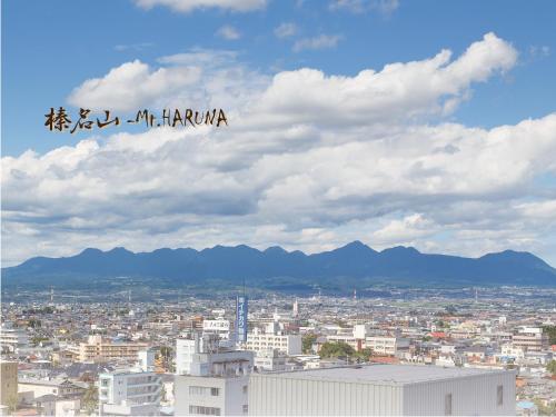 a view of a city with a sign in the sky at Hotel Grand View Takasaki in Takasaki