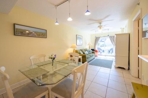 a dining room and living room with a glass table at The Terraces #202-Condo - Pool in Fernandina Beach