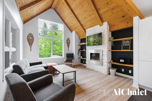 een woonkamer met een bank en een open haard bij The Bear - Escapade en Nature avec Spa in Petite-Rivière-Saint-François