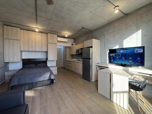 a large room with a bed and a kitchen at Loft Céntrico con Piscina, Gym y Vistas in Monterrey