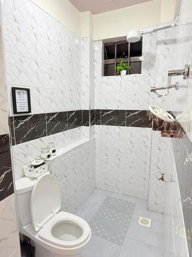 a white bathroom with a toilet and a shower at UrbanHive Naivasha Townhouse in Naivasha