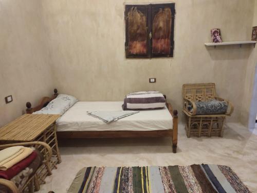una camera con 2 letti singoli e una sedia di إيتران - Itran a Siwa