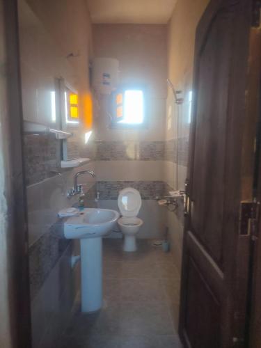 a bathroom with a white toilet and a sink at إيتران - Itran in Siwa