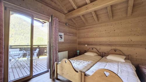 een slaapkamer met een bed in een blokhut bij Chalets à Le Biot - Chalet Mon Frère MAE-4071 in Le Biot