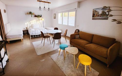 ein Wohnzimmer mit Sofa, Tisch und Stühlen in der Unterkunft Cozy Garden Rooms in Chevilly-Larue