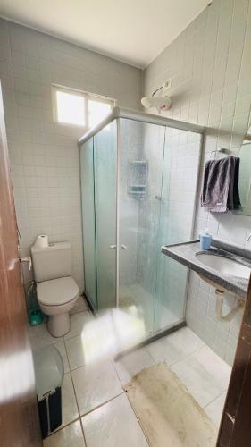 a bathroom with a glass shower and a toilet at Casa Sol e Mar in Tamandaré