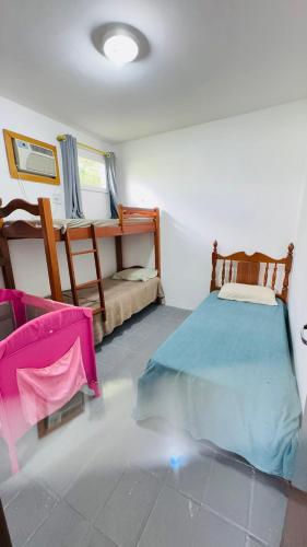 a bedroom with a bed and a table and chairs at Casa Sol e Mar in Tamandaré